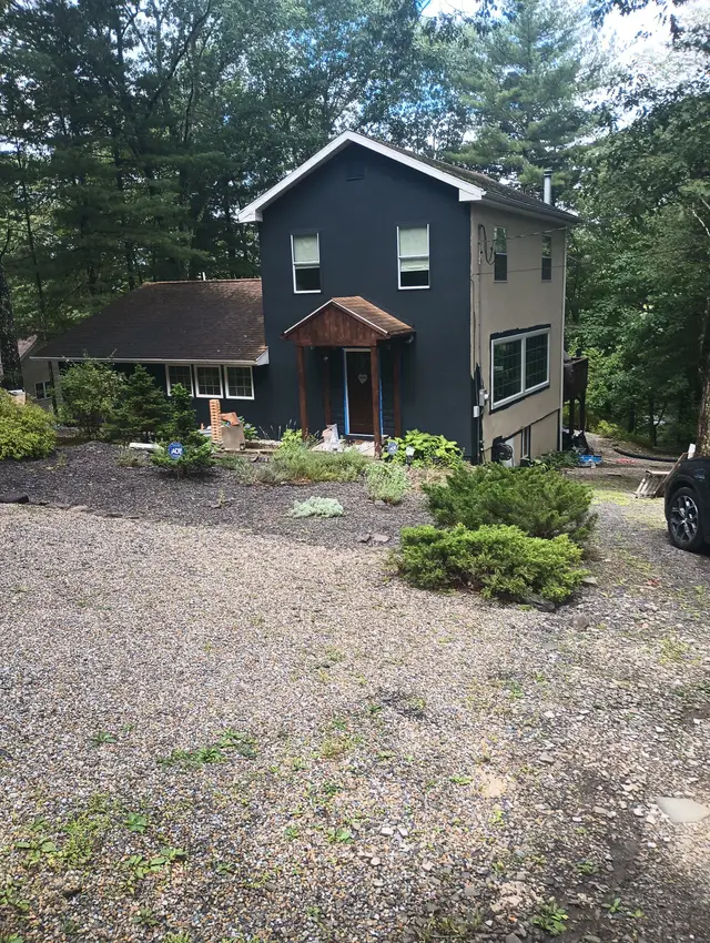 After: the same house, painted a deep charcoal-slate.