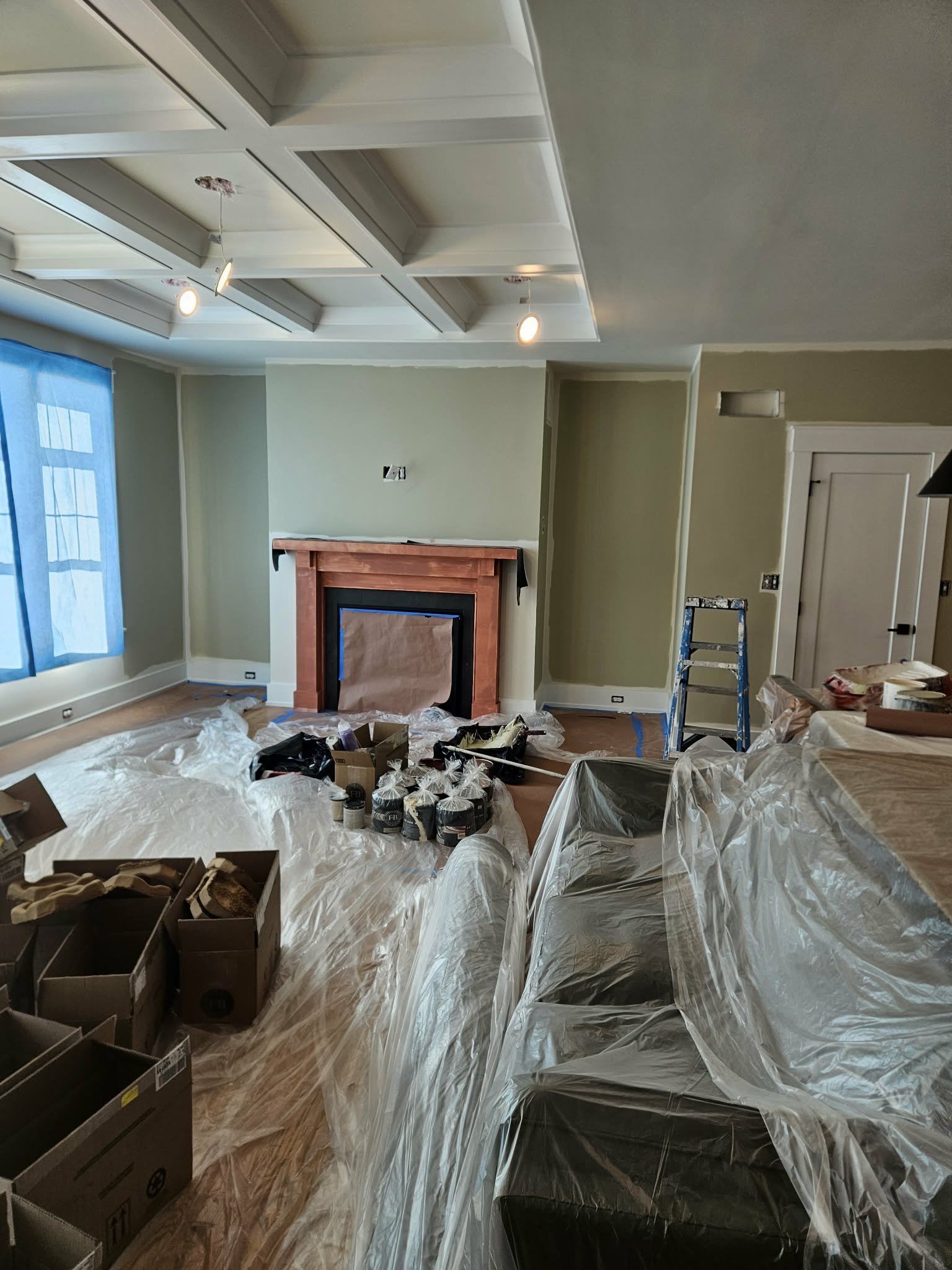 Great room mid-renovation, coffered ceiling and fireplace mantel primed and prepped - interior painting.